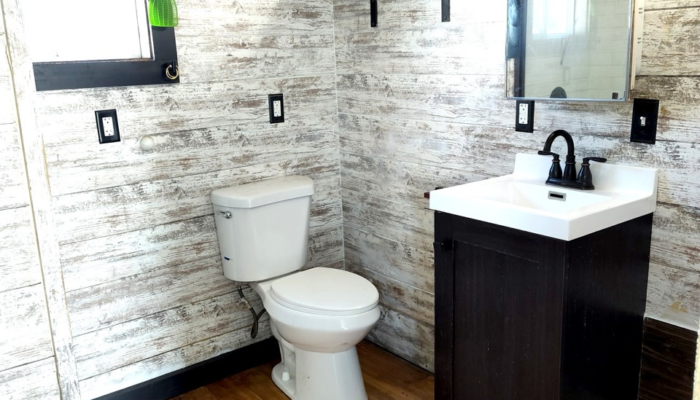 Tiny house bathroom with black vanity and farmhouse style lighting in Orlando rental Tiny house bathroom with black vanity and farmhouse style lighting in Orlando rental