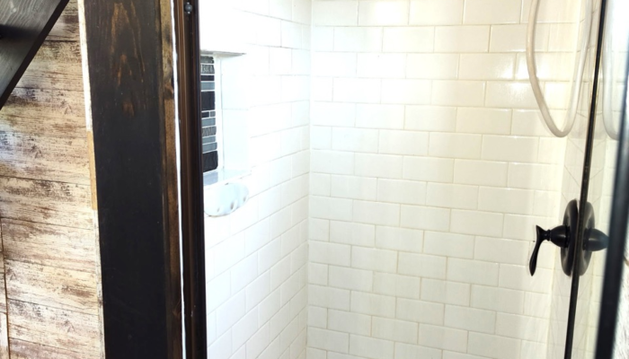 Walk-in shower in tiny house rental with white subway tile and glass door Walk-in shower in tiny house rental with white subway tile and glass door