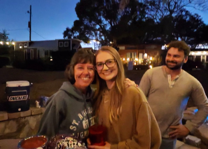 Friends socializing under palm trees at Orlando’s lakefront tiny home community Friends socializing under palm trees at Orlando’s lakefront tiny home community
