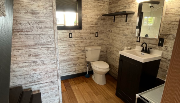 Tiny house bathroom with black vanity and farmhouse style lighting in Orlando rental Tiny house bathroom with black vanity and farmhouse style lighting in Orlando rental